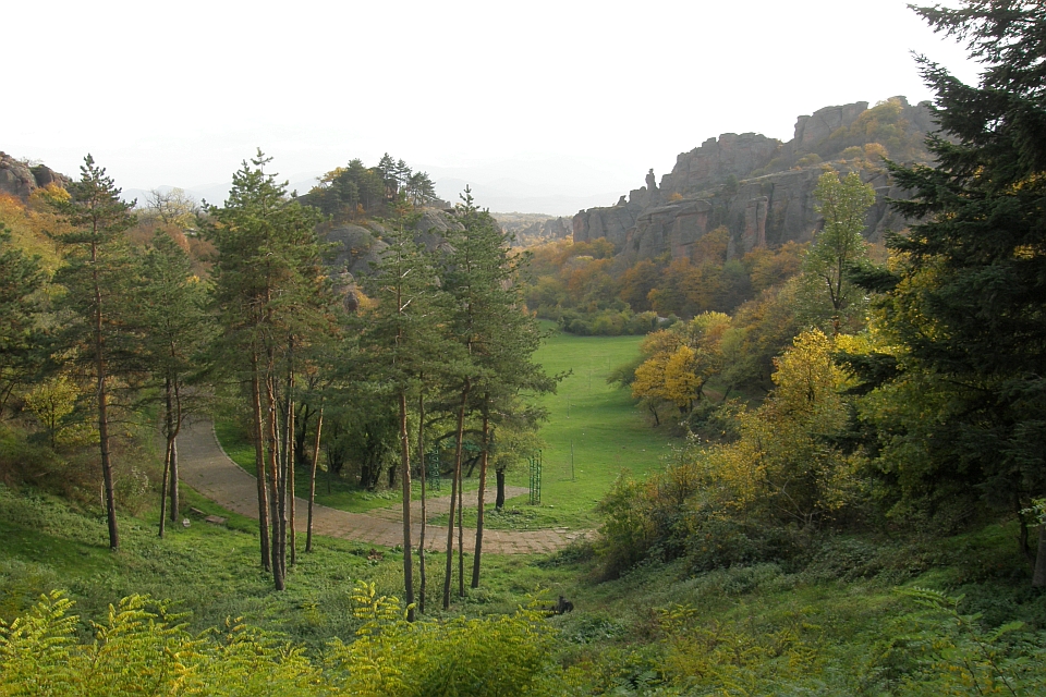Winding Path Curves Through A Lush Green Valley