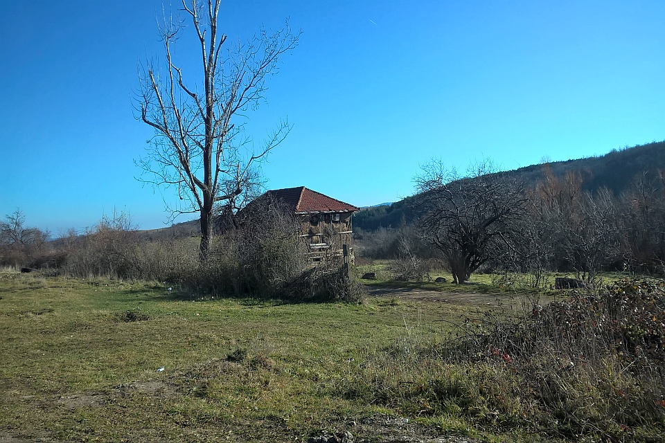 Wooden Structure Stands In A Grassy Field