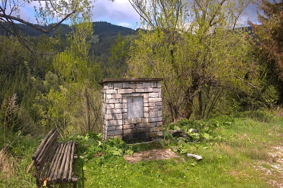 Stone Water Fountain With A Wooden Bench