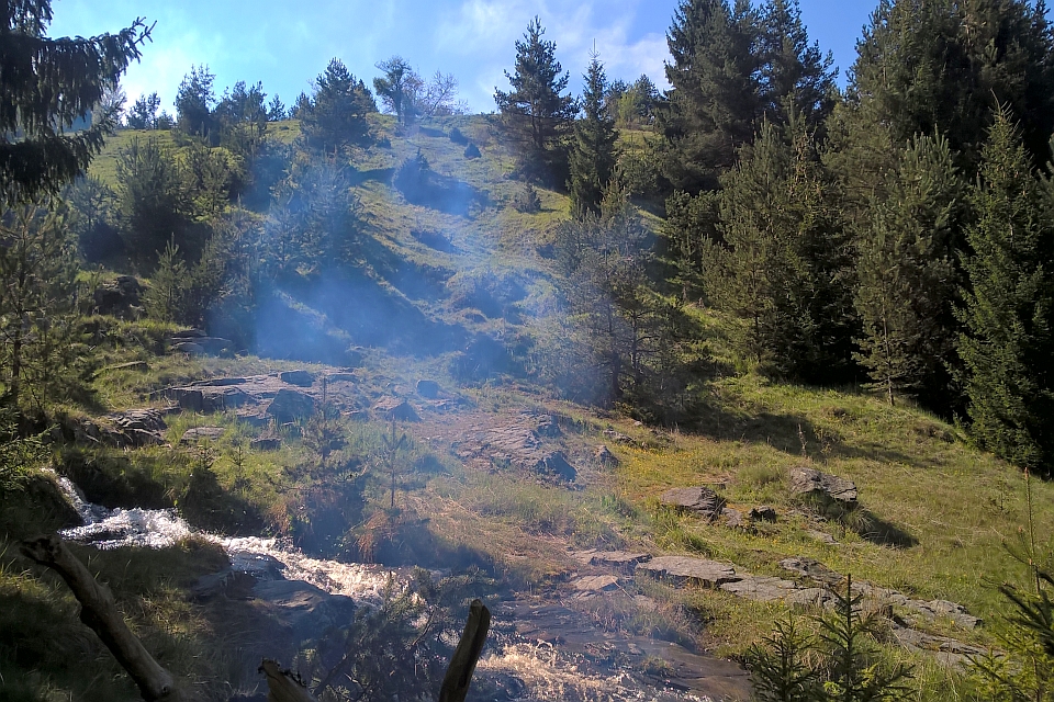 Smoke Drifts Across A Hillside