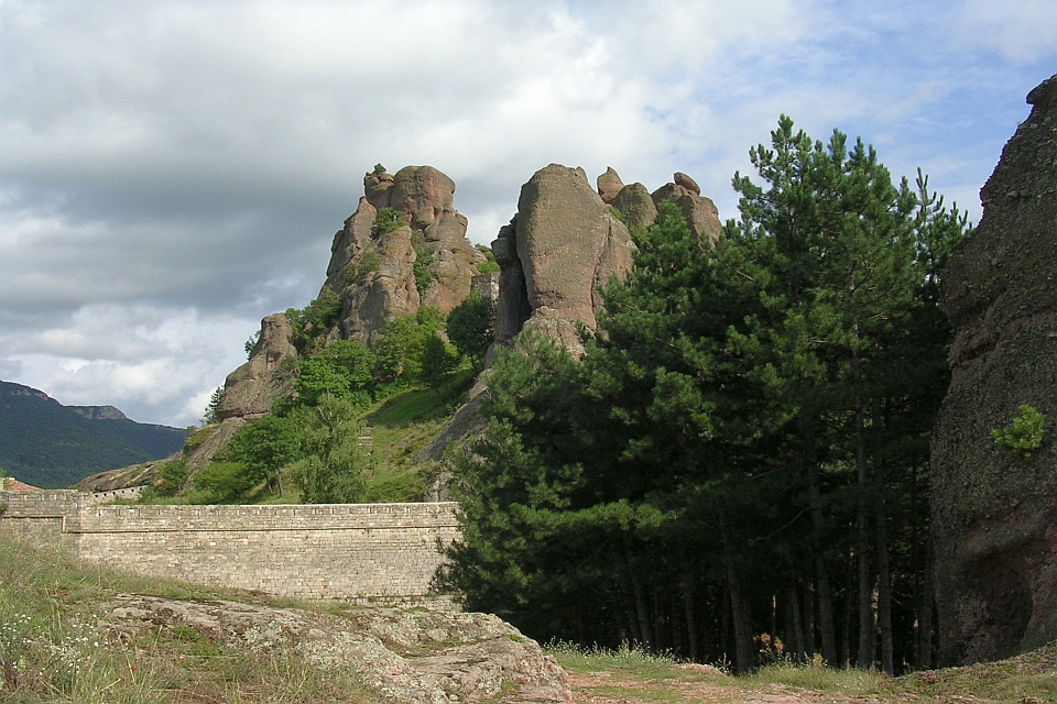 Stone Wall Sits Before Cliff Face