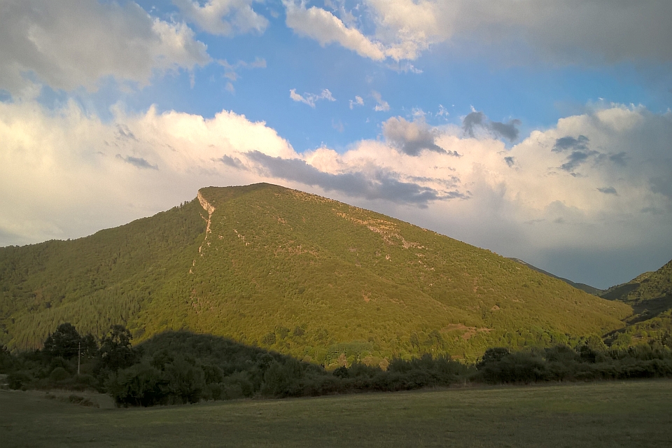 Large, Green Mountain Under A Partly Cloudy Sky