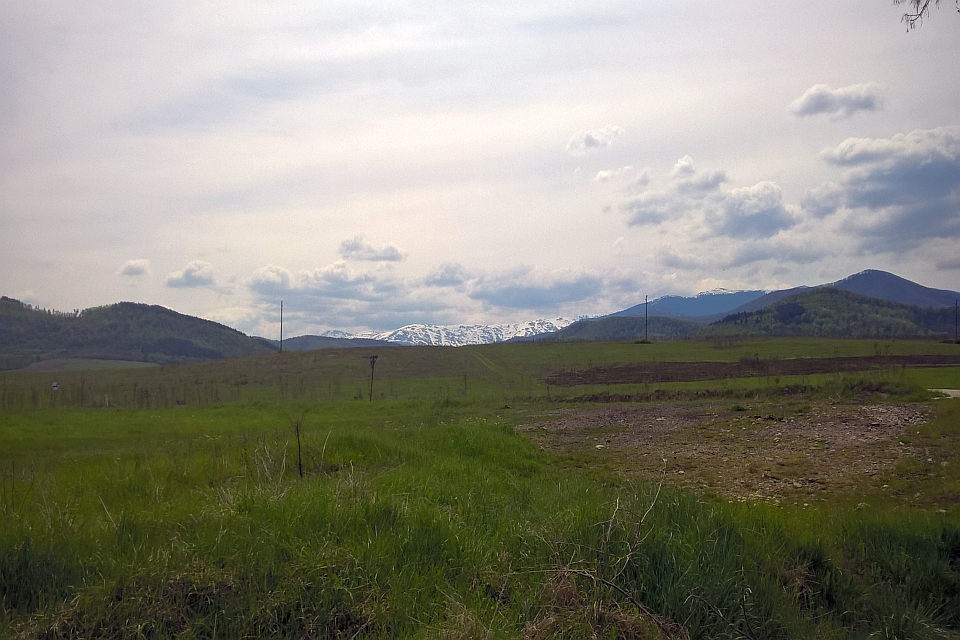 Grassy Field Stretches Towards A Mountain Range