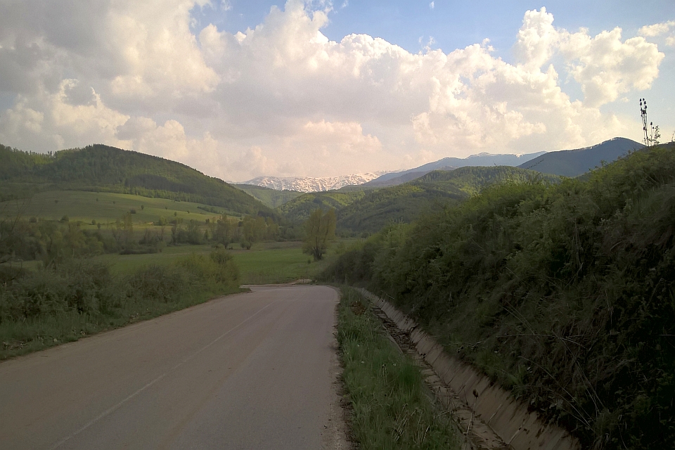 Paved Road Winds Through A Verdant Valley